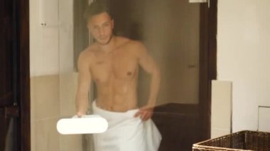 Genç adam saunada dinleniyor, dışarı çıkıyor.