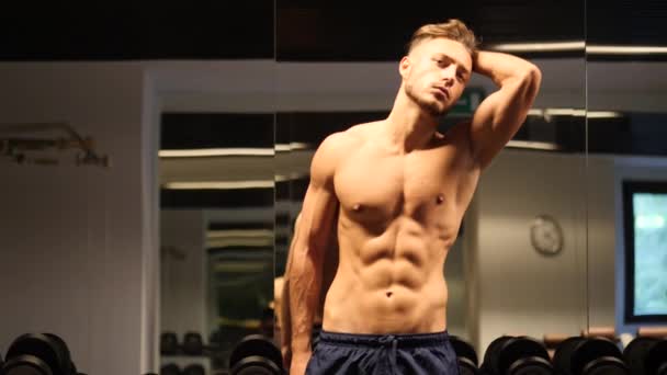 Junger Mann bewundert seine Muskeln im Fitnessspiegel — Stockvideo