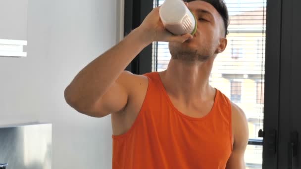 Νεαρός πίνει ένα ρόφημα smoothie ή ένα ρόφημα πρωτεΐνης — Αρχείο Βίντεο