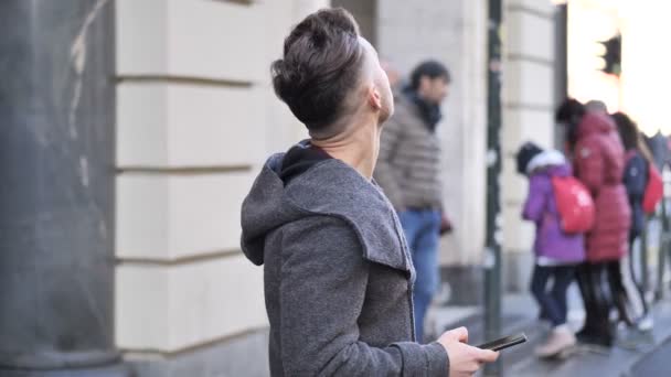 Чоловік загубився в місті, шукаючи напрямки на смартфоні — стокове відео