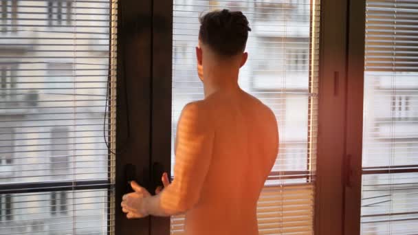 Pensive top less man in shadow stripes from window — Stock video