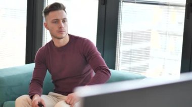 Zafer, yükseltilmiş bir yumruk ile mutlu kutlama TV'de izlerken spor genç adam