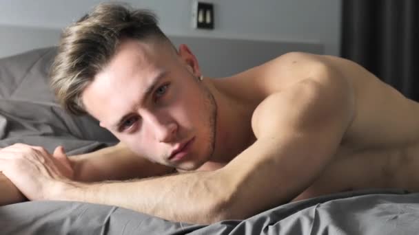 Сексуальний голий молодий чоловік на ліжку вдома — стокове відео