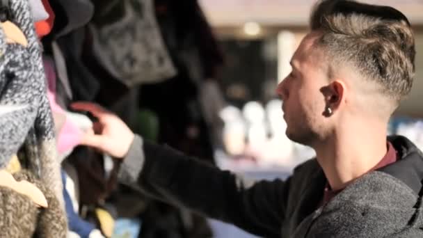 Anak muda browsing melalui produk di pasar udara terbuka — Stok Video
