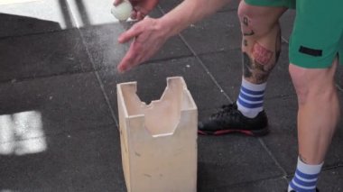 Spor salonunda tebeşir ya da magnezyum tozu kullanan üstsüz bir adam.