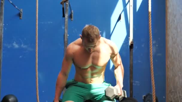一个英俊的年轻人在体育馆锻炼二头肌 — 图库视频影像