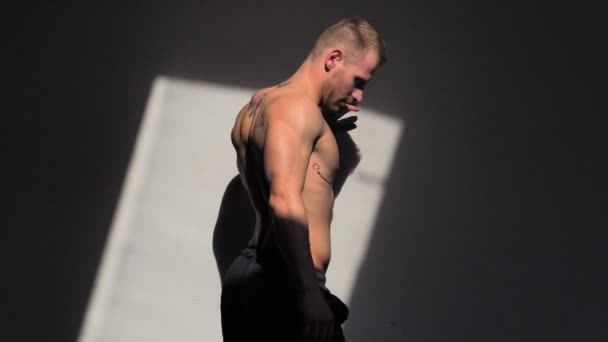 Przystojny bez koszuli muskularny człowiek pozowanie na ścianie — Wideo stockowe
