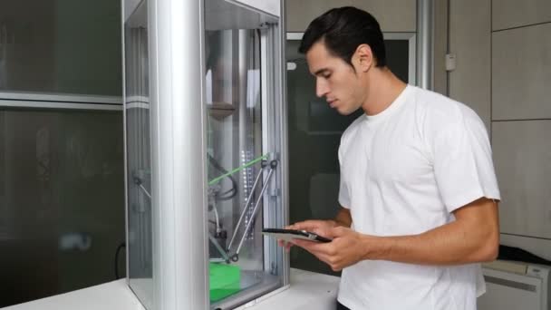 Hombre joven mirando la máquina de la impresora 3d — Vídeos de Stock