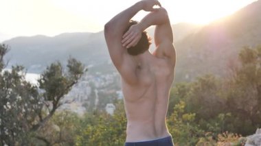Atletik, yakışıklı genç adam açık germe egzersizleri yapıyor ülkede uygun