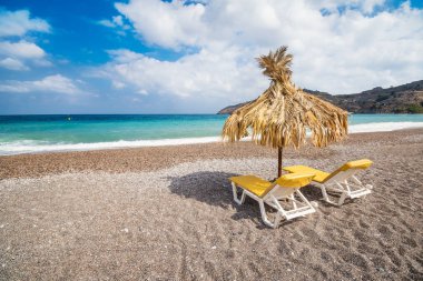 Boş şezlong ve şemsiye Vlycha Beach yakınındaki Lindos köyü (Rhodes, Yunanistan)