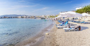 Şezlong ve güneş şemsiyeleri Haraki Beach (Rhodes, Yunanistan)