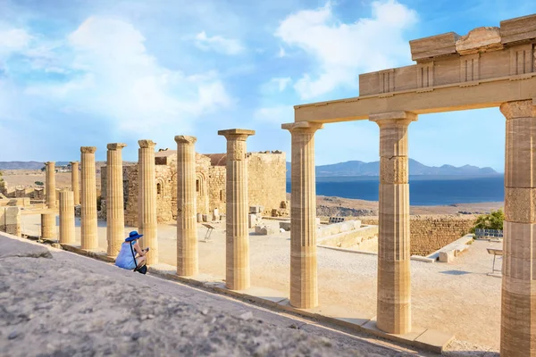 Woman sitting on Staircase of the Propylaea on the Acropolis of Lindos (Rhodes, Greece)