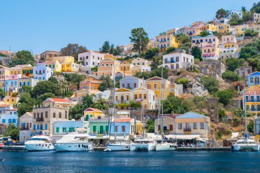 Yelkenli tekneler, tekneler ve liman şehri Symi (Symi Adası, Yunanistan renkli evleri)