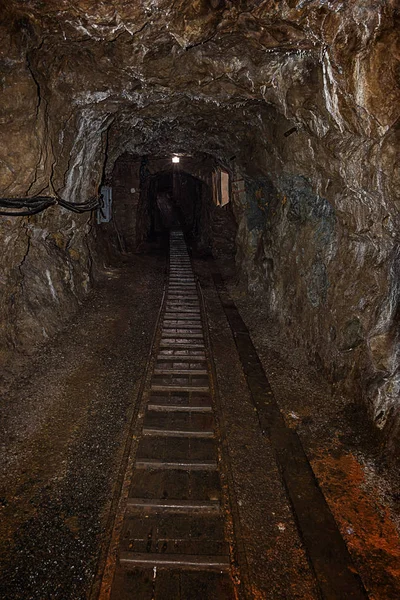 Empty old abandoned mine shaft with rusty railway