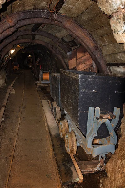 Stary metal kopalni pociąg z kół rusty w kopalni tunel z drewnianym tarasem — Zdjęcie stockowe