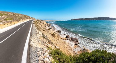 Arka planda uçurtma sörfçüleriyle Prasonisi sahiline giden sahil yolu (Rodos, Yunanistan)