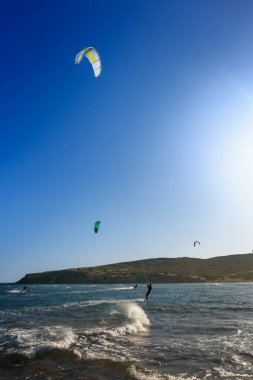 Dalgalarda sörf yapan uçurtmacılarla Prasonisi plajı (Rodos, Yunanistan)
