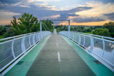 Gün batımında iki ülkeyi birbirine bağlayan boş bisiklet köprüsü (Özgürlük Köprüsü) (Bratislava, SLOVAKIA))