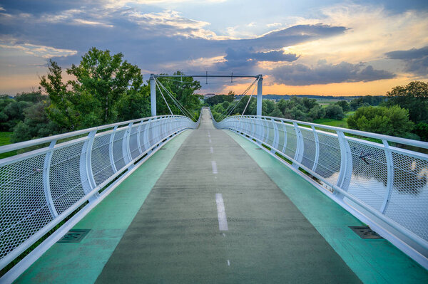 Empty bicycle bridge (called Freedom bridge) connecting two countries Slovakia and Austria during sunset  (Bratislava, SLOVAKIA)