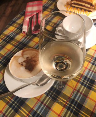 Kapuçino tarçın ve bir bardak beyaz şarap 