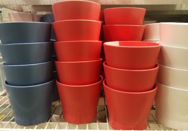 Dükkanda mavi beyaz ve kırmızı çiçek kaplar  