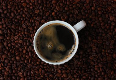 Kahve çekirdekleri ve kahve Americano masada.
