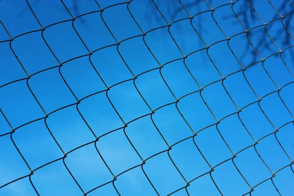 Black metal mesh on the background and blue sky