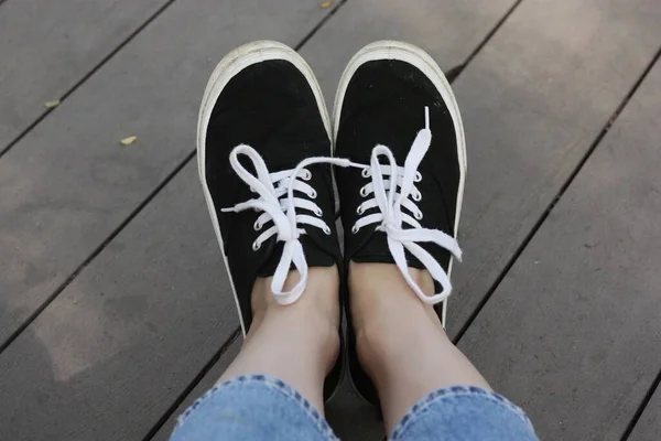 脚上有白色鞋带的黑色运动鞋 — 图库照片