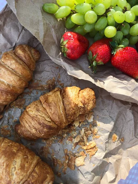 Croissants strawberries and grapes on a picnic
