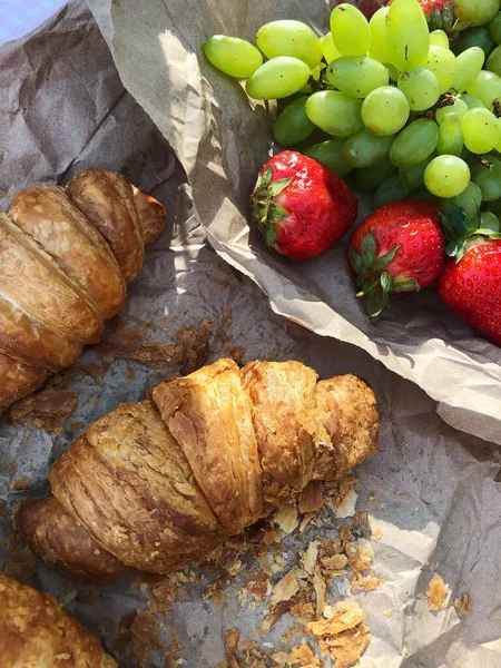 Croissants strawberries and grapes on a picnic