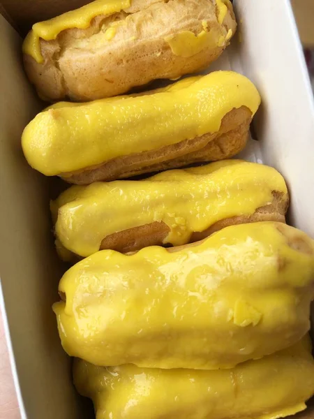 Heerlijke Eclairs Met Geel Glazuur Een Doos — Stockfoto