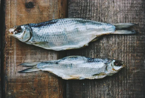 Två Torkade Fiskar Träbakgrund — Stockfoto