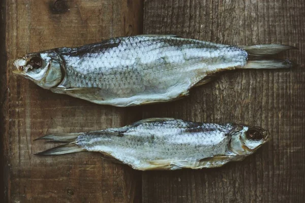 Två Torkade Fiskar Träbakgrund — Stockfoto