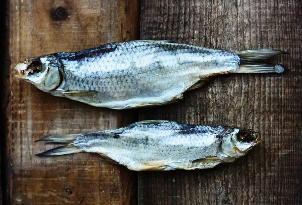 Två Torkade Fiskar Träbakgrund — Stockfoto