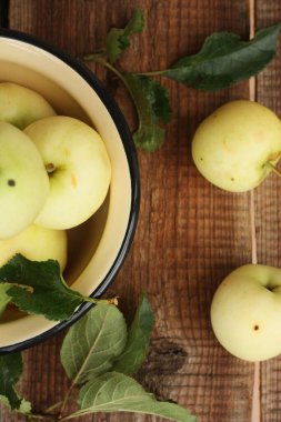 Masada yaprakları olan lezzetli yeşil elmalar.