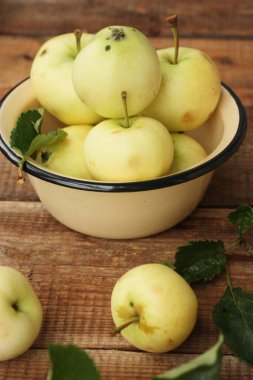 Masada yaprakları olan lezzetli yeşil elmalar.