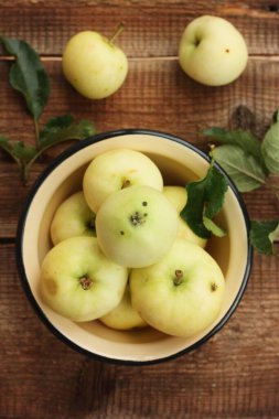 Masada yaprakları olan lezzetli yeşil elmalar.