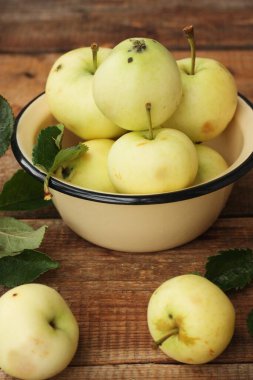 Masada yaprakları olan lezzetli yeşil elmalar.