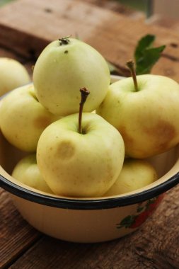 Masada yaprakları olan lezzetli yeşil elmalar.