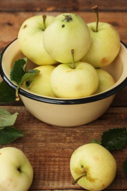 Masada yaprakları olan lezzetli yeşil elmalar.