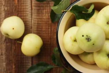Masada yaprakları olan lezzetli yeşil elmalar.