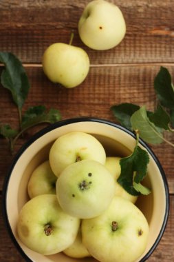 Masada yaprakları olan lezzetli yeşil elmalar.