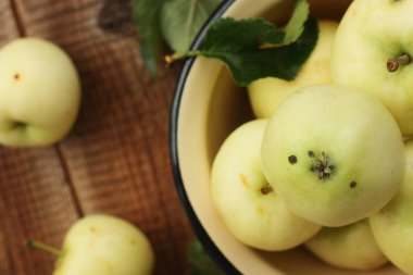 Masada yaprakları olan lezzetli yeşil elmalar.