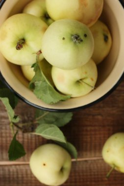 Masada yaprakları olan lezzetli yeşil elmalar.