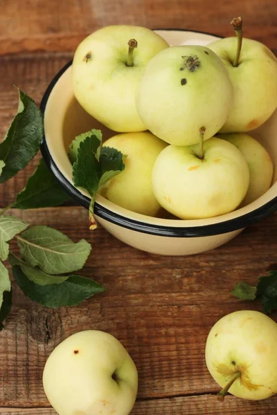 Masada yaprakları olan lezzetli yeşil elmalar.