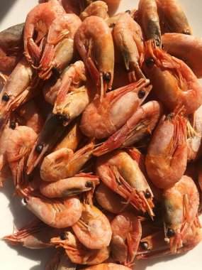 Beyaz bir tabak makroda pişmiş karides. 