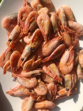 Beyaz bir tabak makroda pişmiş karides. 