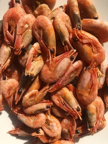 Beyaz bir tabak makroda pişmiş karides. 