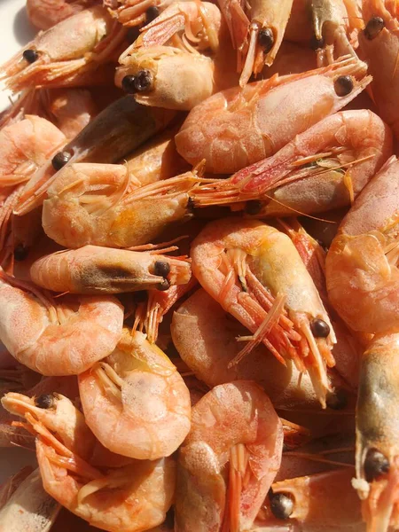 Beyaz bir tabak makroda pişmiş karides. 