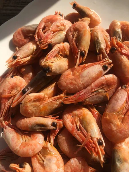 Beyaz bir tabak makroda pişmiş karides. 